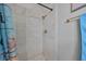 This shower features bronze hardware, new tiling, and a blue shower curtain at 10100 Sailwinds N Blvd # 203, Largo, FL 33773