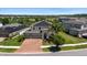 Aerial view of a two-story home with a three-car garage, brick driveway, and solar panels at 10712 Pleasant Knoll Dr, Tampa, FL 33647