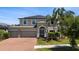 Two-story home with a three-car garage, brick driveway, and well-manicured lawn and landscaping at 10712 Pleasant Knoll Dr, Tampa, FL 33647
