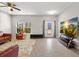 Open-concept living room featuring tile floors, a ceiling fan, and a media center with a large TV at 10712 Pleasant Knoll Dr, Tampa, FL 33647