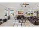 Bright living room features large windows, comfortable seating, ceiling fan, and neutral décor at 10712 Pleasant Knoll Dr, Tampa, FL 33647