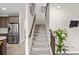 Carpeted staircase with wood railing leads to the upper level of the home, with access to the kitchen on the left at 10712 Pleasant Knoll Dr, Tampa, FL 33647