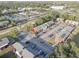 Aerial view of townhomes with gray roofs, red siding, and parking lots surrounded by lush green trees in a quiet neighborhood at 1095 82Nd N Ter # 1095A, St Petersburg, FL 33702