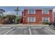 View of brick two-story condo with stairs and blooming shrubs in the parking area at 1095 82Nd N Ter # 1095A, St Petersburg, FL 33702