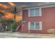 Close-up of a red brick condo showcasing white trim, a private entrance, stairs, and tropical foliage at 1095 82Nd N Ter # 1095A, St Petersburg, FL 33702