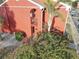 Exterior angled view of a two story condo with red brick, stairs, tropical plants, and a private entry at 1095 82Nd N Ter # 1095A, St Petersburg, FL 33702