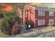 Charming brick condo with a private entry, lush landscaping, stairs leading to the second level, and an orange sky at sunset at 1095 82Nd N Ter # 1095A, St Petersburg, FL 33702