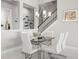 Modern dining area with glass table, sleek white chairs, and contemporary lighting at 11014 Rustic Timber Loop, San Antonio, FL 33576
