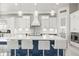 This kitchen features a large center island with seating, white cabinetry, and pendant lighting at 11014 Rustic Timber Loop, San Antonio, FL 33576