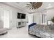 Well-lit main bedroom with ceiling fan, tile floors, mirrored dresser, and access to ensuite bath at 11014 Rustic Timber Loop, San Antonio, FL 33576