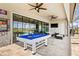 Entertainer's patio boasting a pool table, television, and sleek outdoor furniture for leisure and recreation at 11014 Rustic Timber Loop, San Antonio, FL 33576