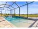 Stunning screened-in pool with a waterfall feature and panoramic views of the lush backyard at 11014 Rustic Timber Loop, San Antonio, FL 33576