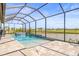 Stunning pool and spa featuring a waterfall under a screened enclosure with beautiful water views at 11014 Rustic Timber Loop, San Antonio, FL 33576