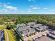 Aerial view of townhomes showing colorful exteriors, lush trees and landscaping at 1103 Coral Ln, Dunedin, FL 34698