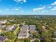 Aerial view of a residential neighborhood showcasing multiple townhomes, landscaping, and community pool under a cloudy sky at 1103 Coral Ln, Dunedin, FL 34698