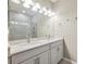 Bright bathroom featuring double vanity with granite countertop and tiled shower with glass door at 1103 Coral Ln, Dunedin, FL 34698
