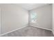 Well-lit bedroom with neutral walls, plush carpeting, and a window at 1103 Coral Ln, Dunedin, FL 34698