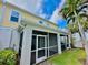 Rear exterior view of home shows screened-in lanai and lush landscaping at 1103 Coral Ln, Dunedin, FL 34698