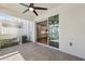 Relax on the brick-paved screened lanai with ceiling fan and view to the kitchen at 1103 Coral Ln, Dunedin, FL 34698