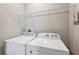 Bright laundry room with washer, dryer, and wire shelving at 1103 Coral Ln, Dunedin, FL 34698
