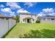 A large backyard is enclosed with a white fence and a small covered patio at 11231 Spring Point Cir, Riverview, FL 33579