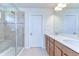 Bright bathroom featuring a double sink vanity and a glass-enclosed shower with tiled surround at 11231 Spring Point Cir, Riverview, FL 33579