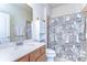 Bathroom with a single sink vanity, a white cabinet, and a shower with a city skyline curtain at 11231 Spring Point Cir, Riverview, FL 33579