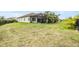 Spacious backyard featuring lush green grass, mature landscaping, and a screened-in lanai at 13121 Pasture View Loop, Riverview, FL 33579