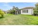 Expansive backyard featuring a well-manicured lawn, tropical landscaping, and a screened-in patio at 13121 Pasture View Loop, Riverview, FL 33579