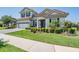 A charming two-story home features an expansive lawn, lush bushes, and a welcoming entrance at 13121 Pasture View Loop, Riverview, FL 33579