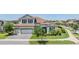 A stunning home with a three-car garage, beautifully landscaped front yard, and a charming terracotta tile roof at 13121 Pasture View Loop, Riverview, FL 33579