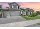 Charming two-story home with a brick driveway, well-manicured lawn, and a tile roof at 13121 Pasture View Loop, Riverview, FL 33579