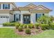 Elegant home featuring manicured landscaping, a tile roof, and a charming double-door entry at 13121 Pasture View Loop, Riverview, FL 33579