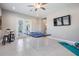 Bright game room with tile floors, ping pong table, and access to the outdoor patio at 13121 Pasture View Loop, Riverview, FL 33579