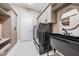 Well-equipped laundry room with modern appliances, cabinetry, and a utility sink at 13121 Pasture View Loop, Riverview, FL 33579
