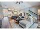 Open concept living room with a staircase, plank flooring, and a kitchen in the background at 13121 Pasture View Loop, Riverview, FL 33579