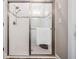 Clean white tiled walk-in shower with glass doors and sleek fixtures at 13121 Pasture View Loop, Riverview, FL 33579
