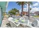 Outdoor deck with stylish white patio furniture, set against a backdrop of sunny skies and lush palm trees at 13200 Boca Ciega Ave, Madeira Beach, FL 33708