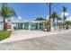Charming light blue home featuring a carport and a small, inviting front porch with white trim at 13200 Boca Ciega Ave, Madeira Beach, FL 33708