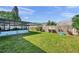 An exterior view of backyard, including grass, fence, and a screened-in porch at 13308 Kearney Way, Tampa, FL 33626