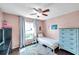 Cozy bedroom with a twin bed, blue dresser, and a decorative rug, illuminated by natural light at 13308 Kearney Way, Tampa, FL 33626