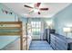 Bright bedroom featuring a wooden bunk bed, blue dressers, and a stylish blue geometric rug at 13308 Kearney Way, Tampa, FL 33626