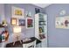 Close up of a cozy bedroom with light purple walls, a desk, and shelves filled with decorations at 13308 Kearney Way, Tampa, FL 33626