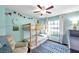 Decorated bedroom with a bunkbed, blue rug, and a bright window allowing natural light at 13308 Kearney Way, Tampa, FL 33626