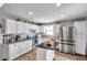 Bright kitchen featuring white cabinets, stainless steel appliances, and a functional center island at 13308 Kearney Way, Tampa, FL 33626