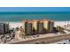 Stunning aerial view of beachfront condos boasting tile roofs, palm trees, and a gorgeous sandy beach at 13600 Gulf Blvd # 700A, St Petersburg, FL 33708