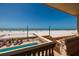 Breathtaking beach view from a balcony with a swimming pool and lounge chairs at 13600 Gulf Blvd # 700A, St Petersburg, FL 33708