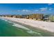 Aerial view of beautiful beachfront condos featuring a sandy beach, blue ocean water, and clear blue skies at 13600 Gulf Blvd # 700A, St Petersburg, FL 33708