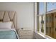 Bright bedroom featuring elegant furnishings, a nightstand, and a window with a scenic ocean view at 13600 Gulf Blvd # 700A, St Petersburg, FL 33708