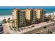 Exterior view of condos overlooking the beach with open balconies, palm trees, and street access at 13600 Gulf Blvd # 700A, St Petersburg, FL 33708